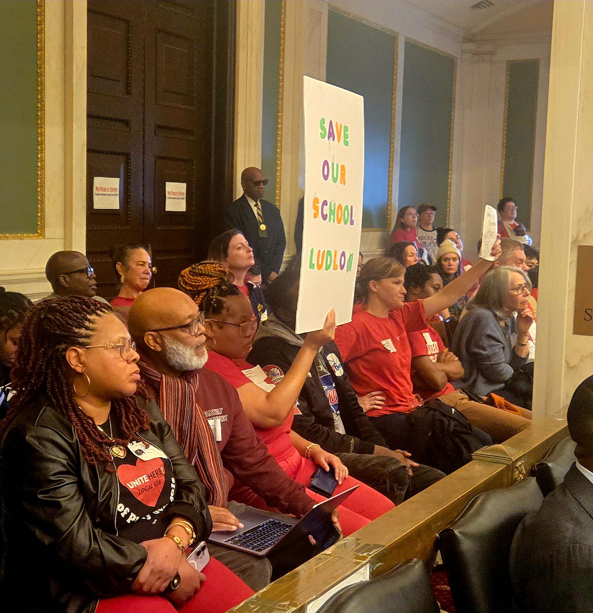 PFT members hold up signs urging City Council to force the District to rethink its 10-year Facilities Master Plan